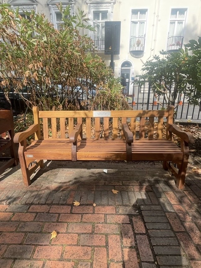 Front view of Gregory G. Caiazzo's memorial bench in Norfolk Square Gardens, Paddington, London